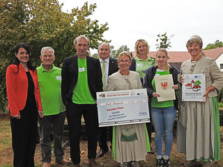 Als Zweitplatzierter erhält der Ort Garlitz einen Scheck von 5.000 Euro. Der Siegerehrung wohnten auch Amtsdirektorin Ilka Lenke (links im Bild) und Dennis Granzow, Dezernent im Landkreis bei, © Landkreis Havelland