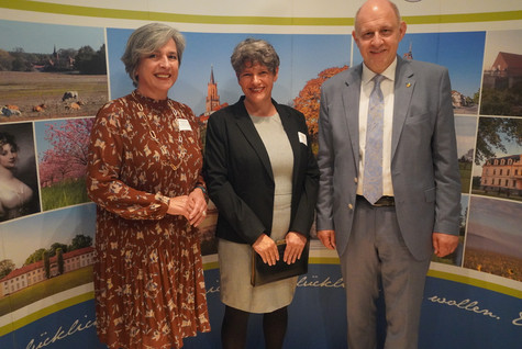 Der Landrat und die Kreistagsvorsitzende begrüßen die Gäste des Sommerempfangs vor einer Werbewand zum Landkreis Havelland - Klick öffnet Bildbetrachter