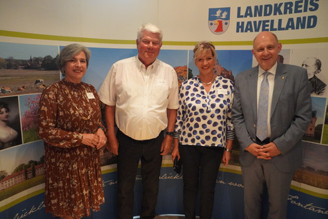 Der Landrat und die Kreistagsvorsitzende begrüßen die Gäste des Sommerempfangs vor einer Werbewand zum Landkreis Havelland - Klick öffnet Bildbetrachter