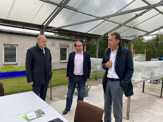 Drei Männer stehen im Halbkreis und unterhalten sich.