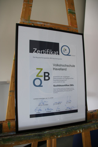 Das Zertifikat steht eingerahmt auf einer Staffelei.