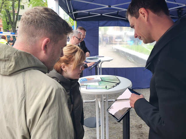 Interessierte Bürger lassen sich die Landkreis-App an einem Tablet erklären - Klick öffnet Bildbetrachter