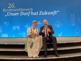 Gudrun Lewwe und Landrat Roger Lewandowski lächeln in die Kamera und zeigen ihre nach oben ausgestreckten Daumen.