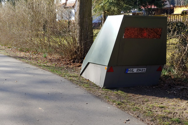 Ein mobiler Blitzer steht am Rand eines Weges.