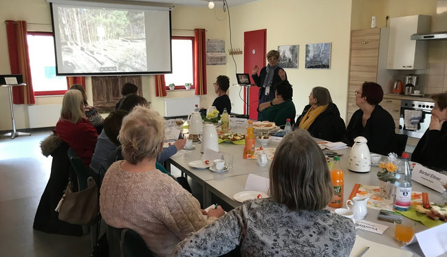 Klick öffnet Bildbetrachter; Gruppe mehrerer Personen bei einer Präsentation