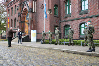 Bundeswehrsoldaten stehen aufgereiht vor dem Kreishaus in Rathenow. Dennis Granzow steht vor ihnen und spricht zu ihnen.