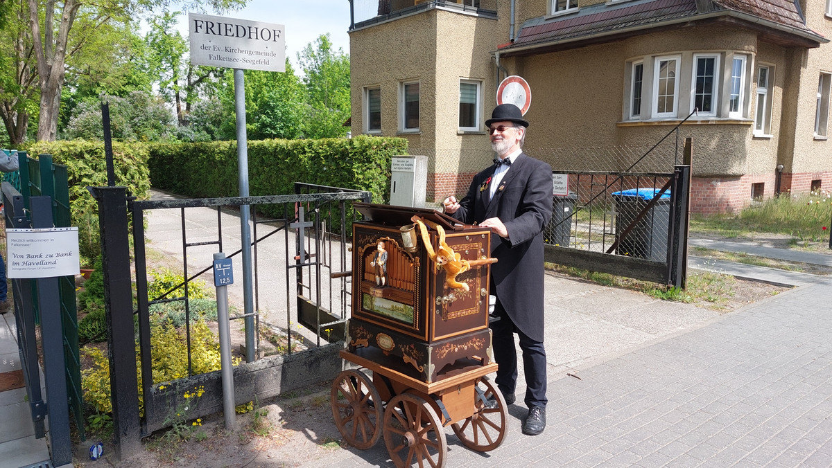 Ein Mann steht an einer Drehorgel - Klick öffnet Bildbetrachter