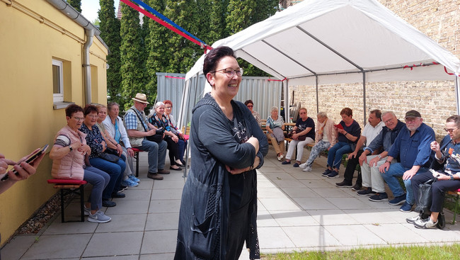 Eine Gruppe von Menschen sitzt unter einem Pavillion - Klick öffnet Bildbetrachter