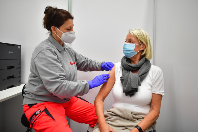 Eine Frau impft eine ältere Dame.