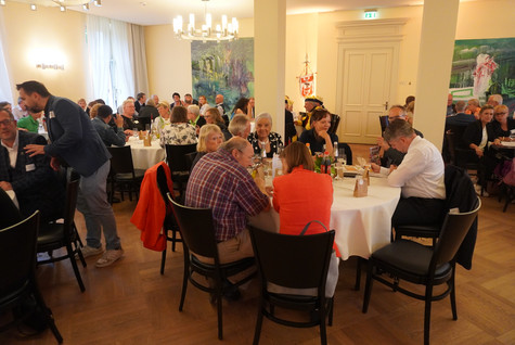 Blick in den Saal, wo die Gäste verteilt an mehreren Tischen sitzen - Klick öffnet Bildbetrachter