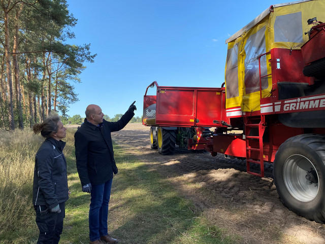 Annette Brockmann und Roger Lewandowski stehen vor einer Landwirtschaftsmaschine.