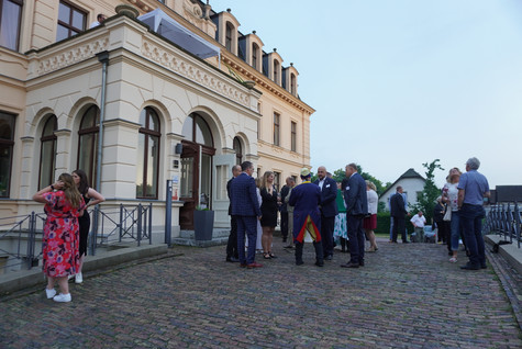 Vor dem Schloss Ribbeck stehen mehrere kleine Gruppen und unterhalten sich - Klick öffnet Bildbetrachter