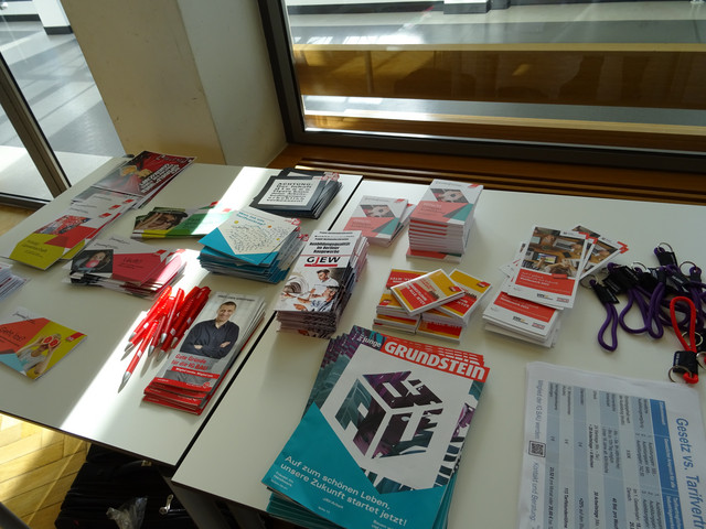 Flyer liegen verteilt auf einem Tisch.