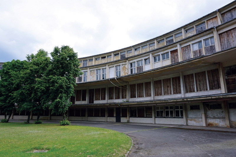 Die historische Aufnahme zeigt einen Teil eines vierstöckigen Gebäudes, das in einem Rundbogen angelegt ist