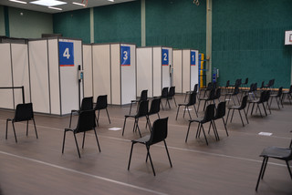 Leere Stuhlreihen vor den vier Impfkabinen in der Havellandhalle.