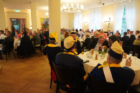 Blick in den Saal, wo die Gäste verteilt an mehreren Tischen sitzen - Klick öffnet Bildbetrachter