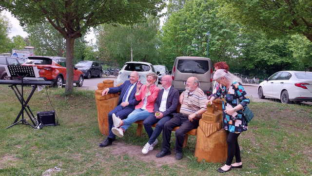 Klick öffnet Bildbetrachter; Personen auf einer Bank sitzend