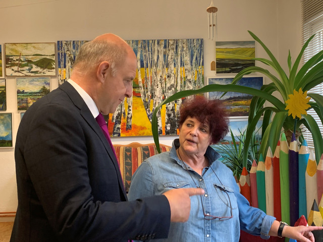 Zwei Personen stehen in einem Atelier und unterhalten sich - Klick öffnet Bildbetrachter