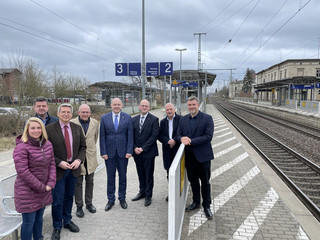 Eine Gruppe von Menschen steht auf einem Bahnsteig - Klick öffnet Bildbetrachter