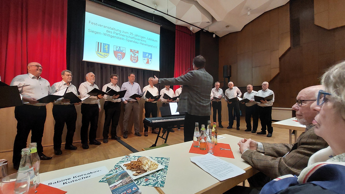 Klick öffnet Bildbetrachter; Gruppe Männer auf einer Bühne