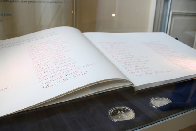 Das aufgeschlagene Ehrenamtsbuch liegt in einer Glasvitrine.