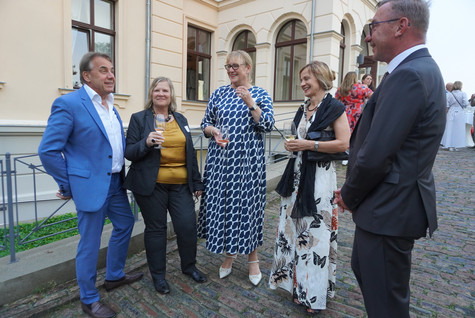 Eine kleine Gruppe steht vor dem Schloss Ribbeck - Klick öffnet Bildbetrachter