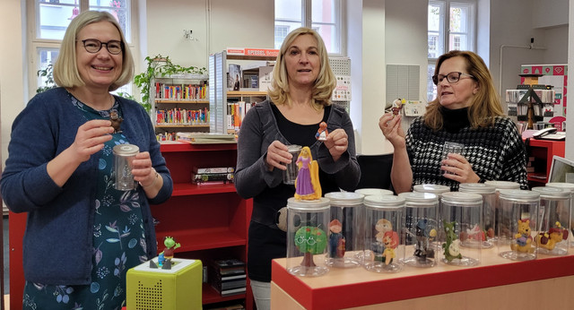 Klick öffnet Bildbetrachter; drei Frauen in einer Bibliothek