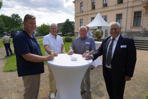 Gäste der Veranstaltung stehen verteilt auf einer Grünfläche vor dem Schloss Ribbeck - Klick öffnet Bildbetrachter