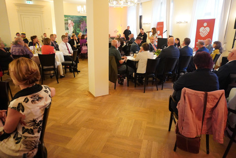 Blick in den Saal, wo die Gäste verteilt an mehreren Tischen sitzen und ein Duo Musik spielt - Klick öffnet Bildbetrachter