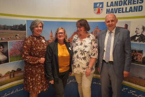 Der Landrat und die Kreistagsvorsitzende begrüßen die Gäste des Sommerempfangs vor einer Werbewand zum Landkreis Havelland - Klick öffnet Bildbetrachter