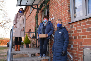 Drei Frauen stehen auf der Treppe eines Wohnhauses.
