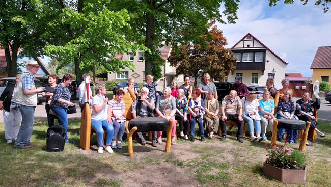 Eine Gruppe von Menschen sitzt auf einer Bankgruppe - Klick öffnet Bildbetrachter