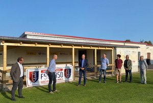 Sieben Männer stehen vor dem Vereinsgebäude.