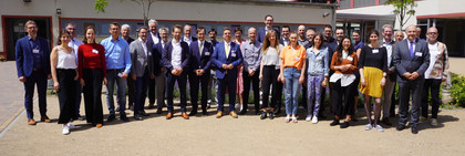 Eine Gruppe von rund 40 Menschen steht versammelt auf einer Freifläche und schaut in die Kamera - Klick öffnet Bildbetrachter