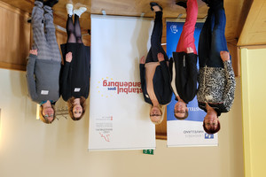 Klick öffnet Text, fünf Frauen vor Plakaten