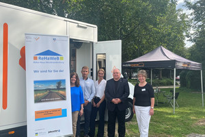 Fünf Personen stehen vor dem Beratungsmobil, im Hintergrund steht ein Pavillon mit Sitzmöglichkeiten - Klick öffnet Bildbetrachter