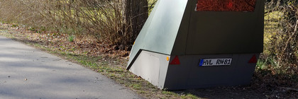 Ein mobiler Blitzer steht am Rand eines Weges.