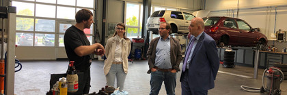 Klick öffnet Artikel, vier Personen in einer Autowerkstatt