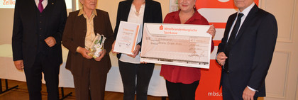 Fünf Personen stehen nebeneinander. In der Mitte die Preisträger mit ihren Preisen.