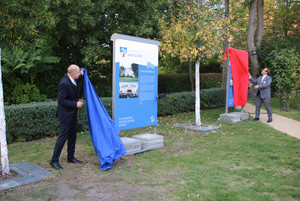 Landrat Roger Lewandowski und Nauens Bürgermeister Manuel Meger enthüllen zwei der Stelen, die mit einem Tuch verhüllt waren.