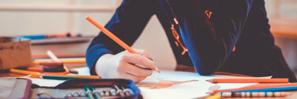 Ein Kind sitzt im Klassenzimmer und malt.