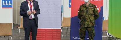 Zwei Männer stehen nebeneinander vor einem Aufsteller mit der Aufschrift "Landkreis Havelland".