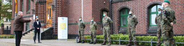 Bundeswehrsoldaten stehen aufgereiht vor dem Kreishaus in Rathenow. Dennis Granzow steht vor ihnen und spricht zu ihnen.