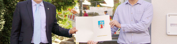 Roger Lewandowski und Károly Bakó zeigen den Fördermittelbescheid.