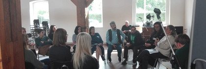 Klick öffnet Bildbetrachter; eine Gruppe von Erwachsenen tauscht sich aus