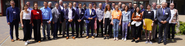 Eine Gruppe von rund 40 Menschen steht versammelt auf einer Freifläche und schaut in die Kamera - Klick öffnet Bildbetrachter