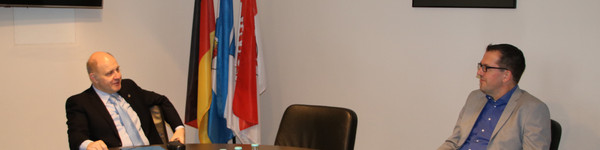 Landrat Lewandowski und Bürgermeister Richter sitzen an einem Tisch.