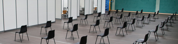 Blick in die Havellandhalle, wo leere Stuhlreihen vor den zukünftigen Impfkabinen stehen.