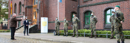 Bundeswehrsoldaten stehen aufgereiht vor dem Kreishaus in Rathenow. Dennis Granzow steht vor ihnen und spricht zu ihnen.