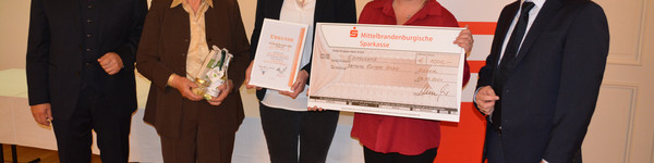 Fünf Personen stehen nebeneinander. In der Mitte die Preisträger mit ihren Preisen.